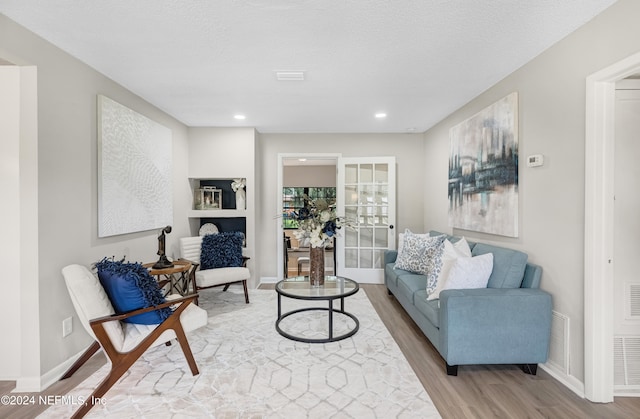 living room with a textured ceiling and hardwood / wood-style floors