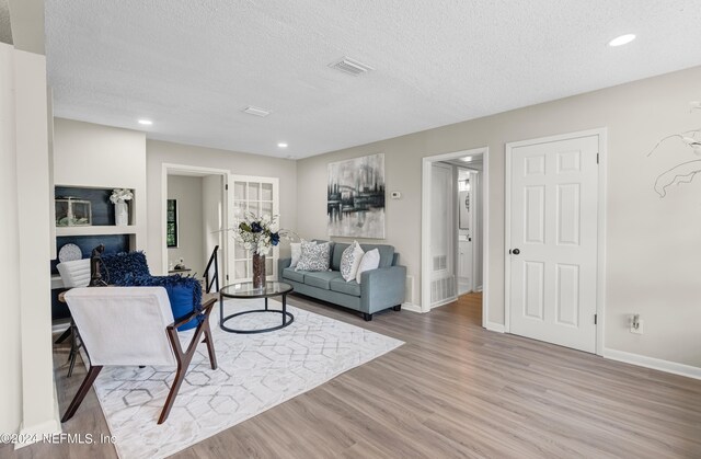 living room featuring a textured ceiling and hardwood / wood-style flooring