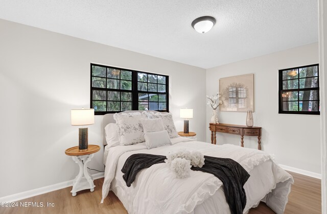 bedroom with wood-type flooring and a textured ceiling