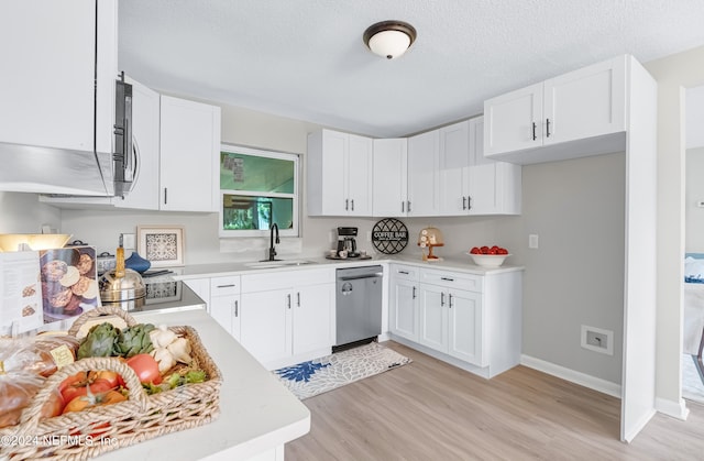 kitchen featuring light wood-type flooring, a textured ceiling, sink, appliances with stainless steel finishes, and white cabinets