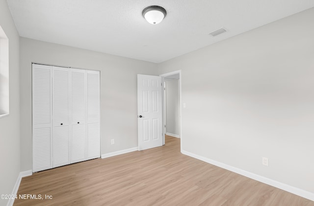 unfurnished bedroom featuring a closet and light wood-type flooring