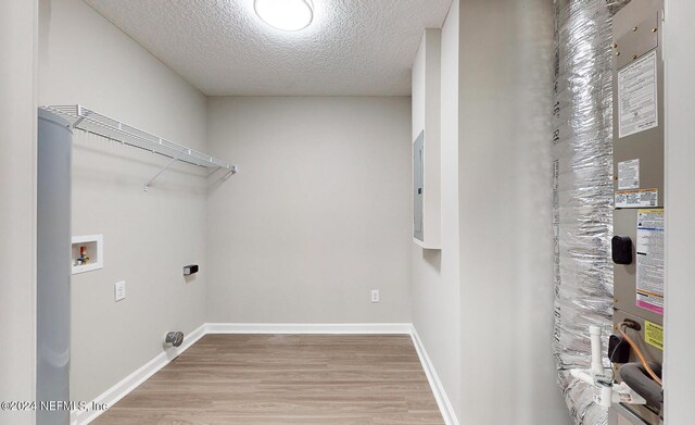 washroom with a textured ceiling, wood-type flooring, hookup for a washing machine, and hookup for an electric dryer