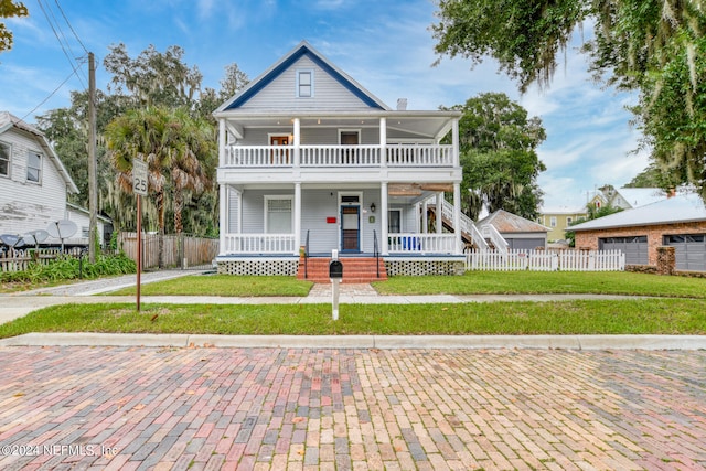 view of front of house featuring a balcony, a front lawn, and covered porch