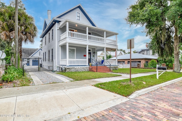 view of front facade with a balcony and a front lawn