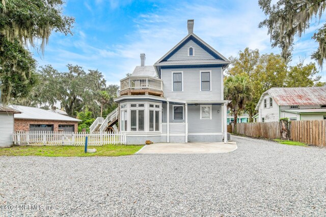 back of property with a patio area and a balcony