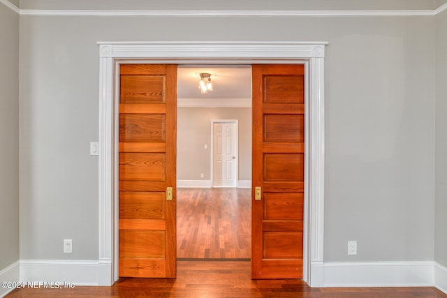 empty room featuring crown molding and wood-type flooring