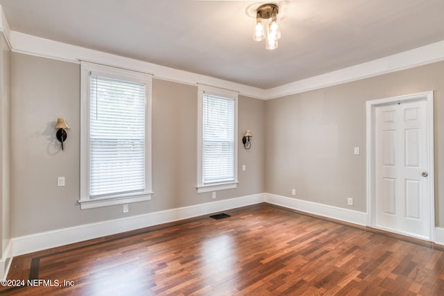 spare room featuring dark hardwood / wood-style floors and ornamental molding