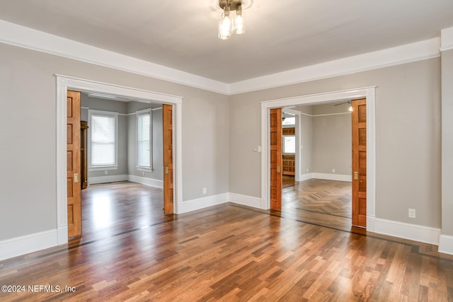 empty room featuring dark hardwood / wood-style flooring and crown molding