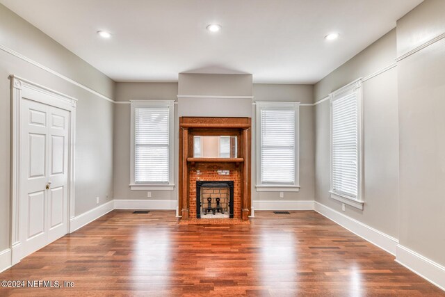 unfurnished living room featuring hardwood / wood-style flooring and a healthy amount of sunlight