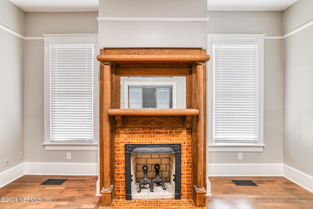 living room with hardwood / wood-style floors and a brick fireplace