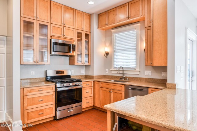 kitchen featuring light stone counters, light tile patterned floors, sink, and appliances with stainless steel finishes