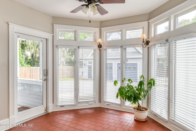 unfurnished sunroom featuring a wealth of natural light and ceiling fan