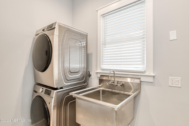 laundry room with plenty of natural light, stacked washer and clothes dryer, and sink