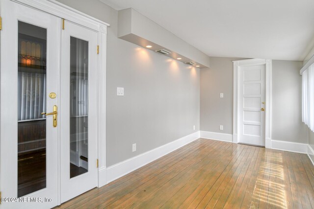 unfurnished room with hardwood / wood-style floors and french doors