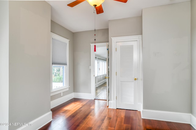 empty room with dark hardwood / wood-style floors and ceiling fan