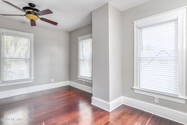 empty room with ceiling fan and dark wood-type flooring