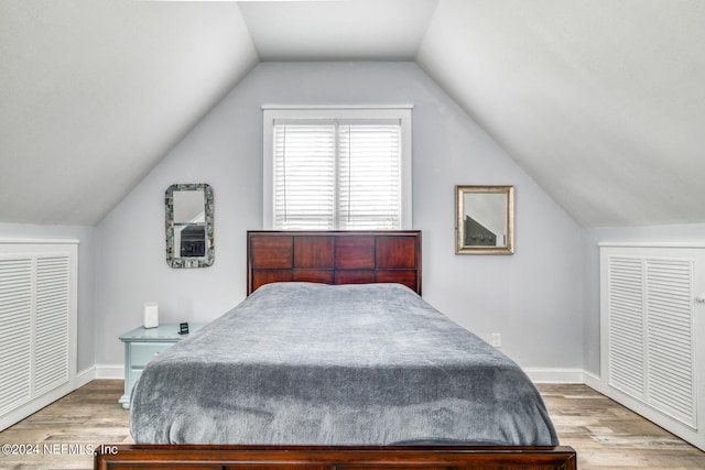 bedroom featuring hardwood / wood-style flooring and lofted ceiling