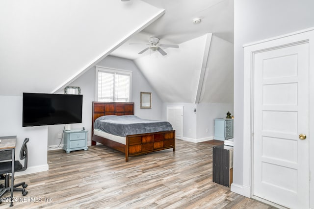 bedroom featuring ceiling fan, light hardwood / wood-style floors, and lofted ceiling