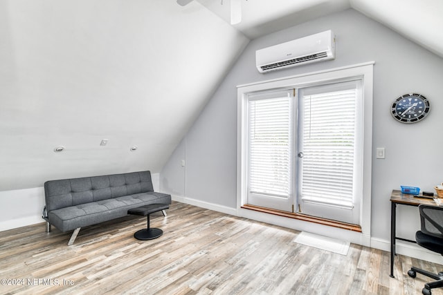 living area with vaulted ceiling, ceiling fan, light hardwood / wood-style floors, and a wall mounted air conditioner