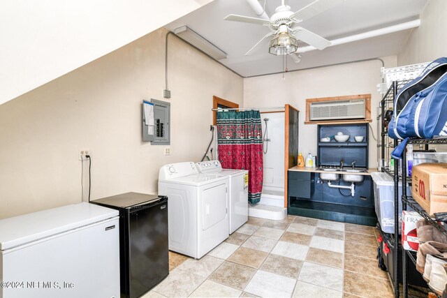 laundry area featuring washer and clothes dryer, ceiling fan, sink, and electric panel