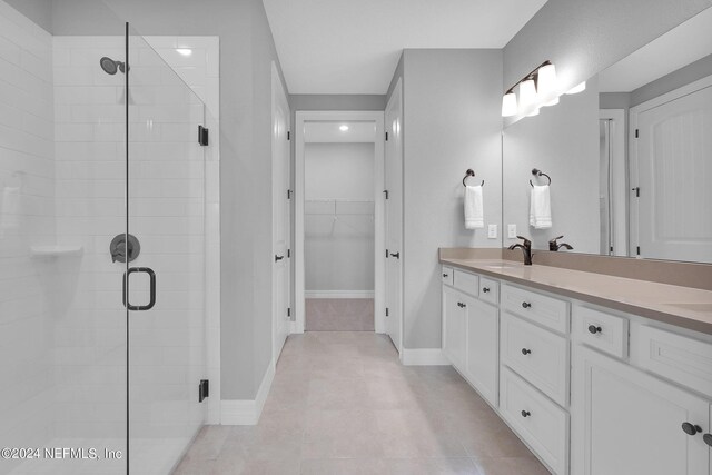 bathroom featuring vanity, an enclosed shower, and tile patterned floors