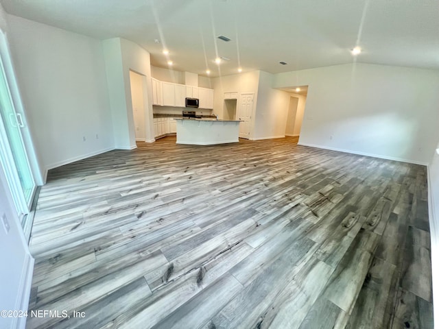 unfurnished living room with light wood-type flooring and lofted ceiling