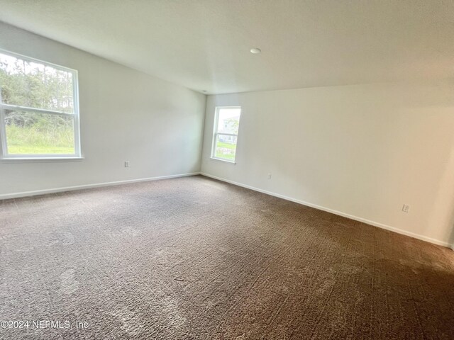 carpeted empty room with baseboards