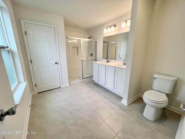 full bath featuring a stall shower, toilet, baseboards, and a sink