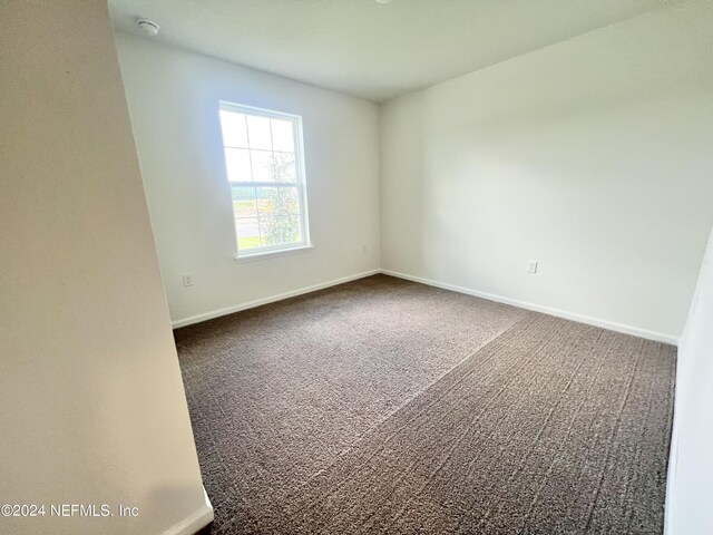 carpeted empty room with baseboards