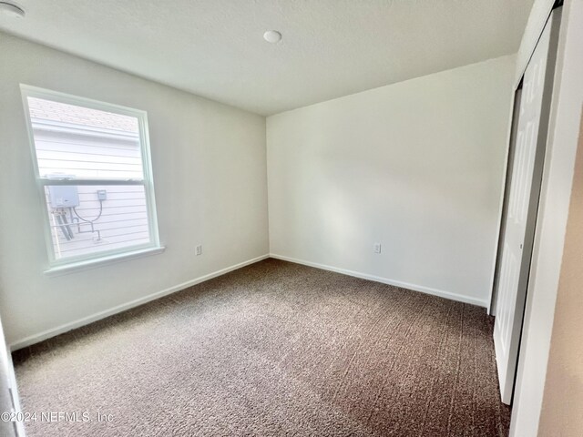 unfurnished bedroom featuring a closet, baseboards, and carpet flooring