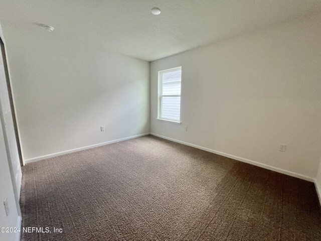 carpeted spare room with baseboards