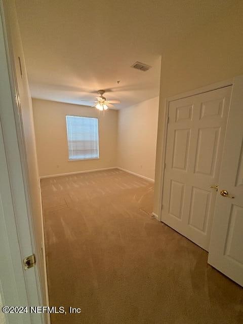 carpeted empty room featuring ceiling fan