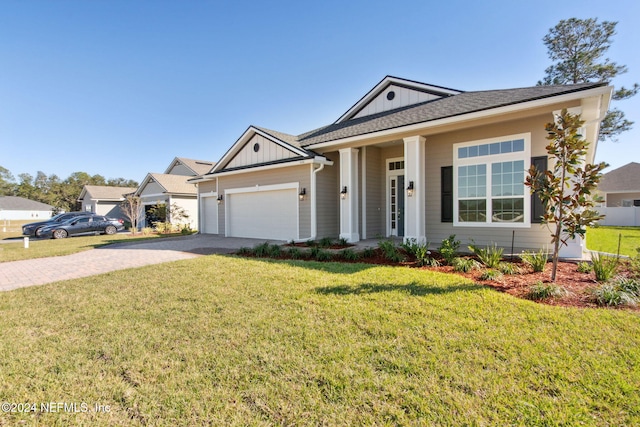 view of front of home with a porch, a garage, and a front yard