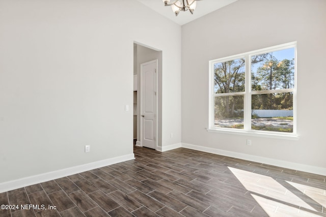 spare room featuring dark hardwood / wood-style floors and a notable chandelier