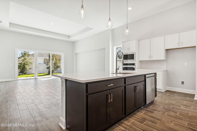 kitchen featuring white cabinets, pendant lighting, stainless steel appliances, and dark hardwood / wood-style floors