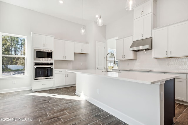 kitchen featuring white cabinets, sink, an island with sink, and appliances with stainless steel finishes