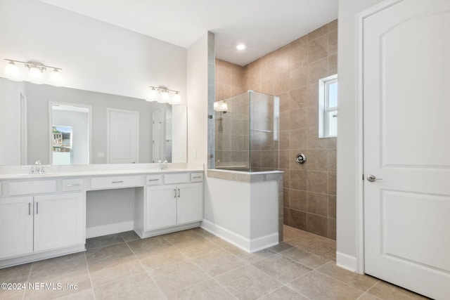 bathroom featuring tile patterned floors, vanity, and tiled shower