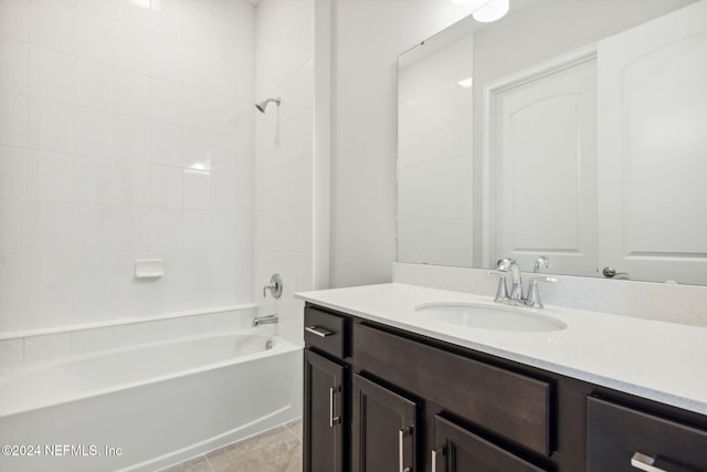 bathroom featuring tile patterned flooring, vanity, and tiled shower / bath