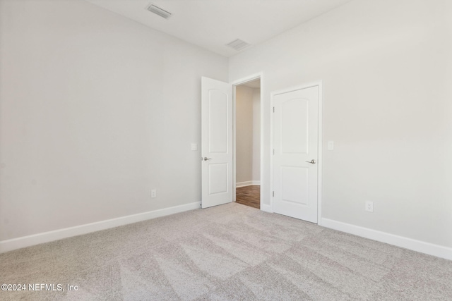 spare room featuring light colored carpet