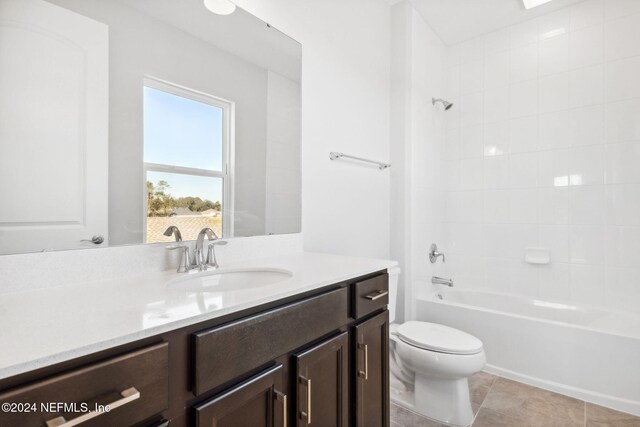 full bathroom with tile patterned flooring, vanity, toilet, and tiled shower / bath combo