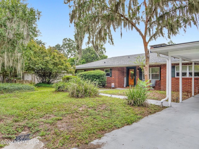 view of front of property featuring a front yard and a carport