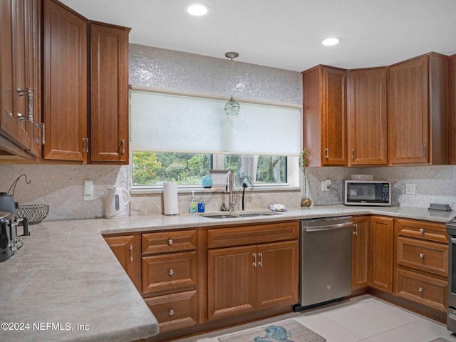 kitchen featuring sink, stainless steel appliances, backsplash, light tile patterned floors, and decorative light fixtures