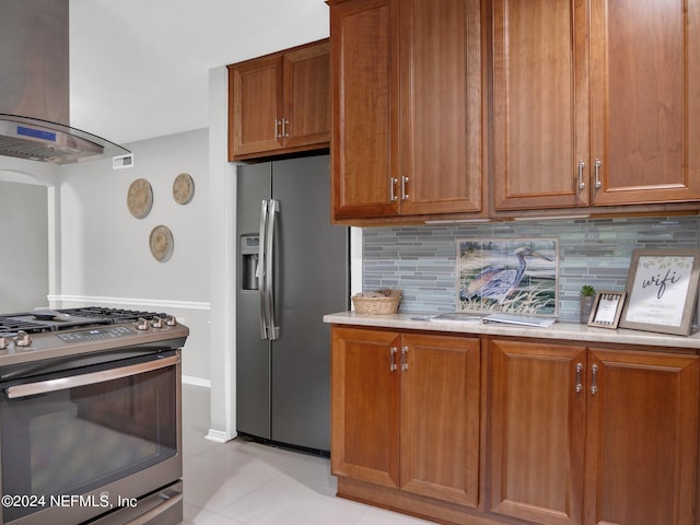 kitchen featuring backsplash, stainless steel appliances, wall chimney exhaust hood, and light tile patterned floors