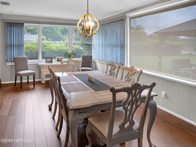 dining space featuring hardwood / wood-style flooring and a chandelier