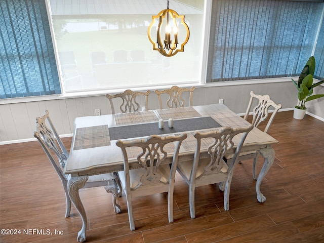 dining space featuring an inviting chandelier and dark hardwood / wood-style flooring