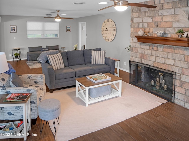 living room with hardwood / wood-style floors, ceiling fan, and a fireplace