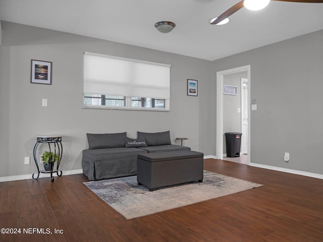 living room with dark hardwood / wood-style flooring and ceiling fan