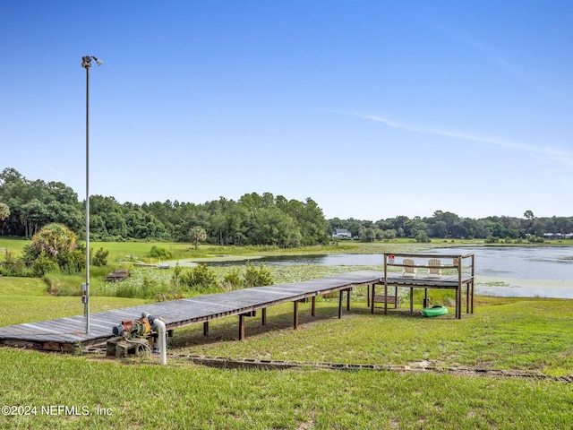 dock area featuring a lawn and a water view