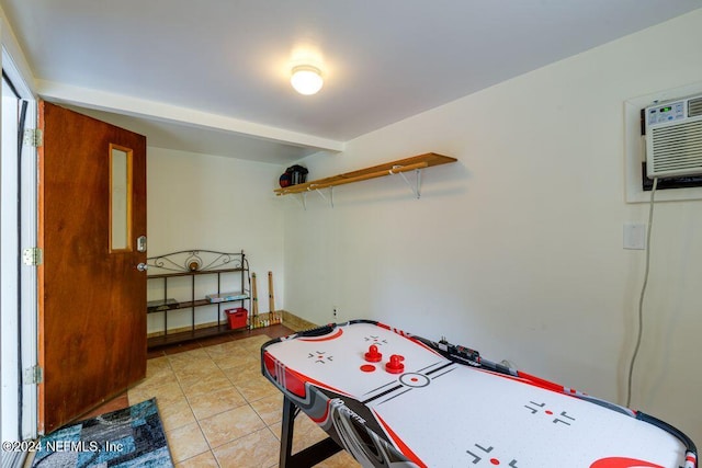 rec room featuring light tile patterned floors and a wall mounted air conditioner