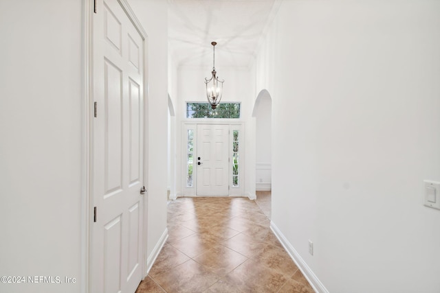 tiled foyer entrance featuring a notable chandelier